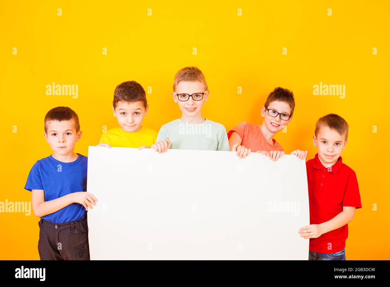 The different little boys are holding a big white paper Stock Photo - Alamy