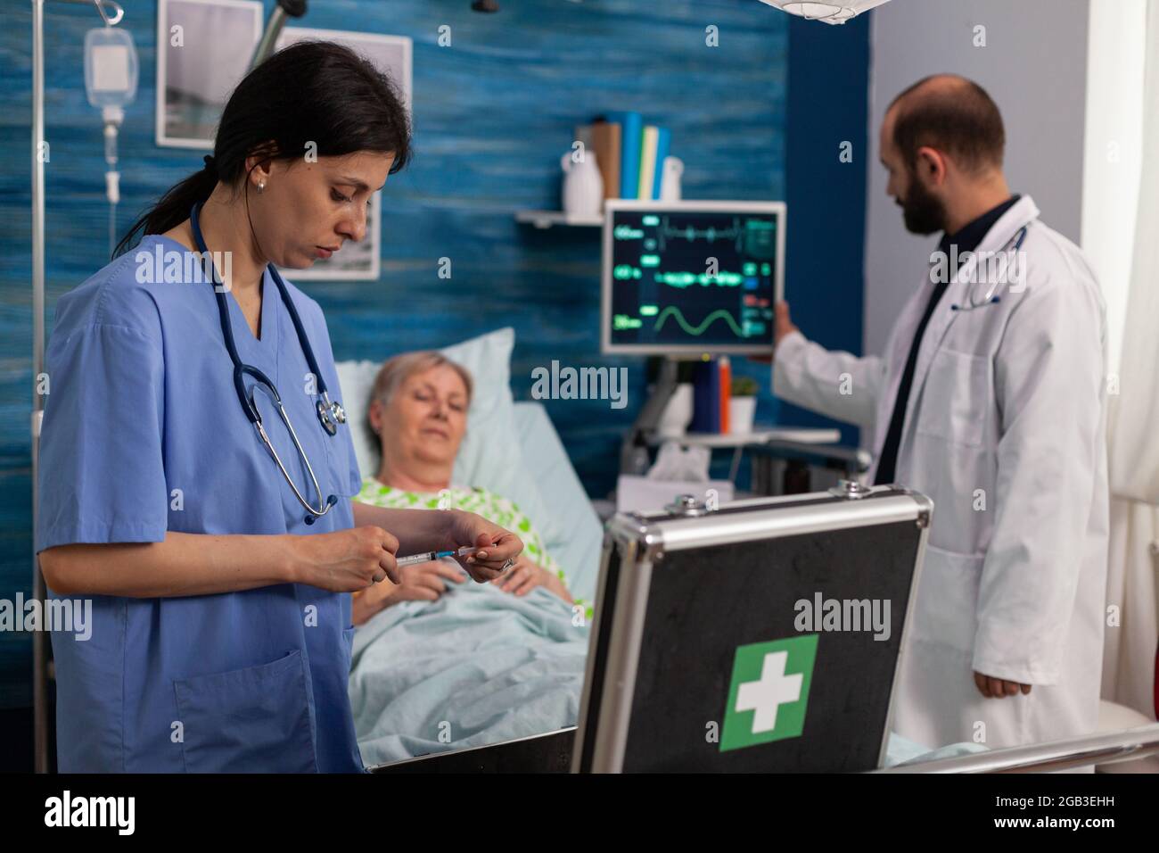 Specialist woman nurse looking at medicine kit bag while social support man nurse during medical examination. Social services nursing elderly retired female. Healthcare assistance. Stock Photo