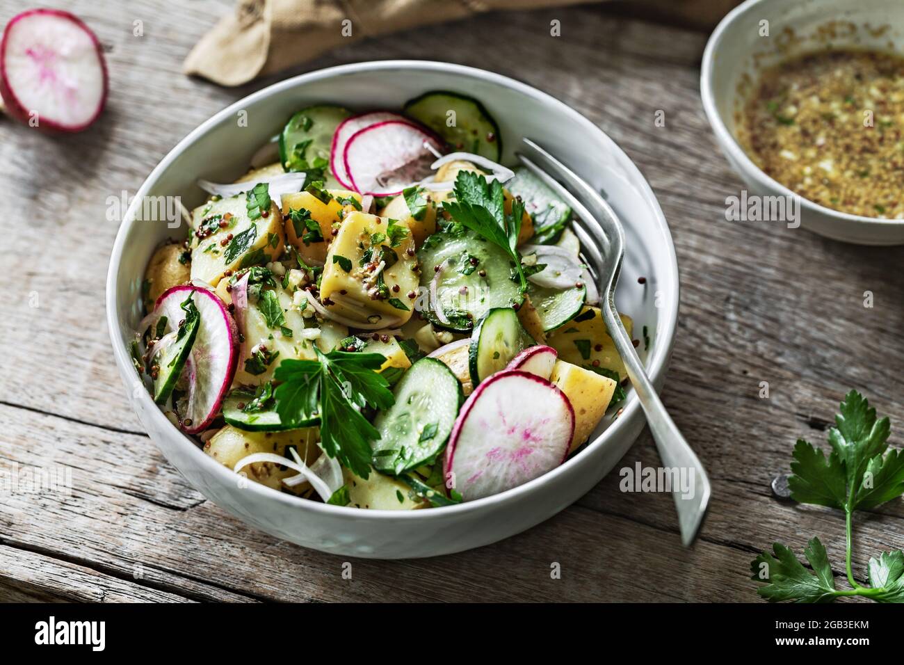 Potato with Cucumber Radish Salad in a wooden bowl Stock Photo