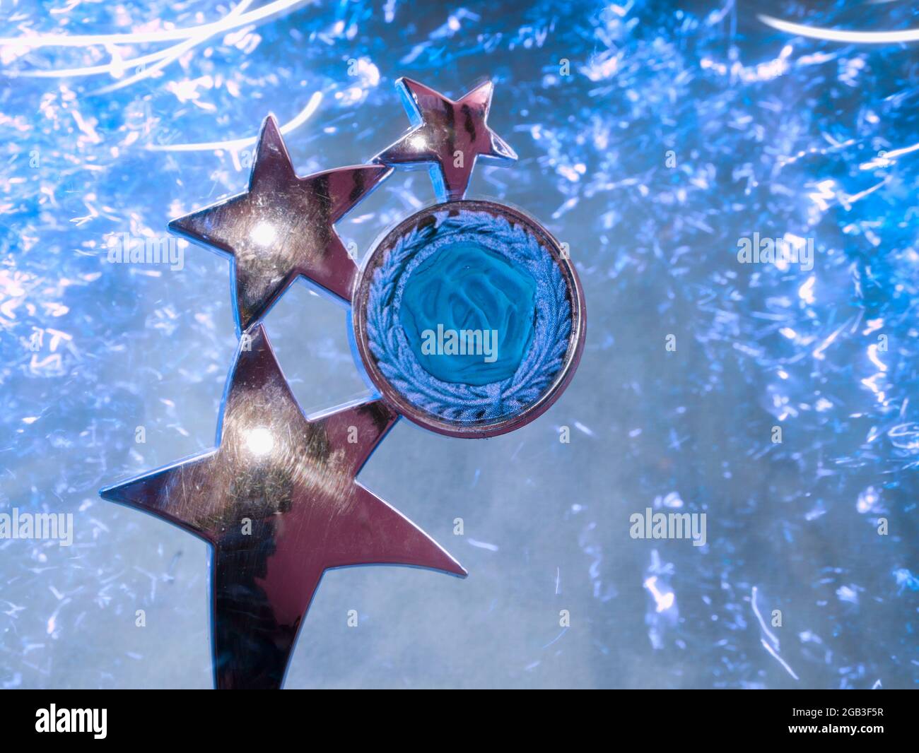 Winning award shield stars presented with bluish light sparkles background. Stock Photo