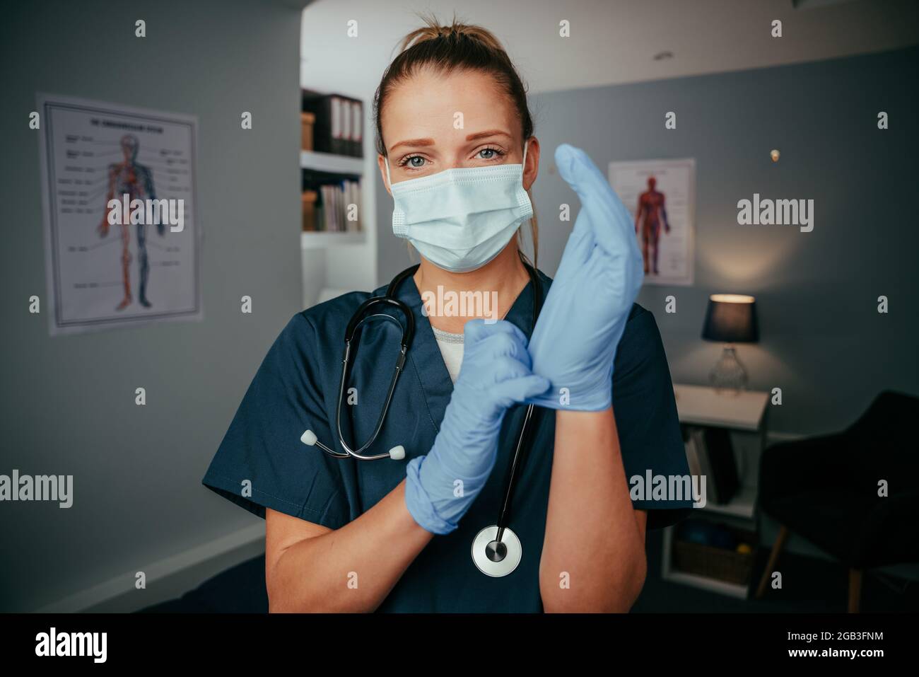 Caucasian female nurse standing in doctors office wearing surgical gear Stock Photo