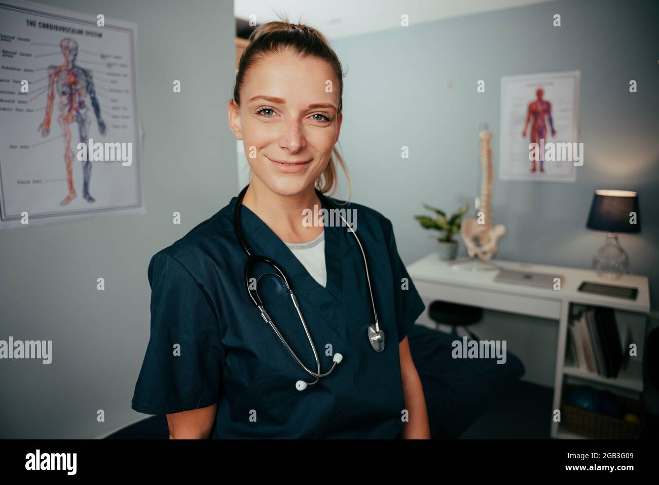 Caucasian female doctor standing in clinic wearing scrubs  Stock Photo