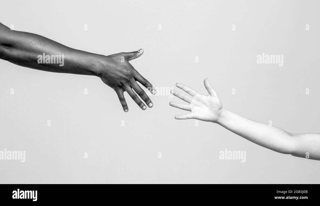 Black and white human hands. African and caucasian hands. Giving a