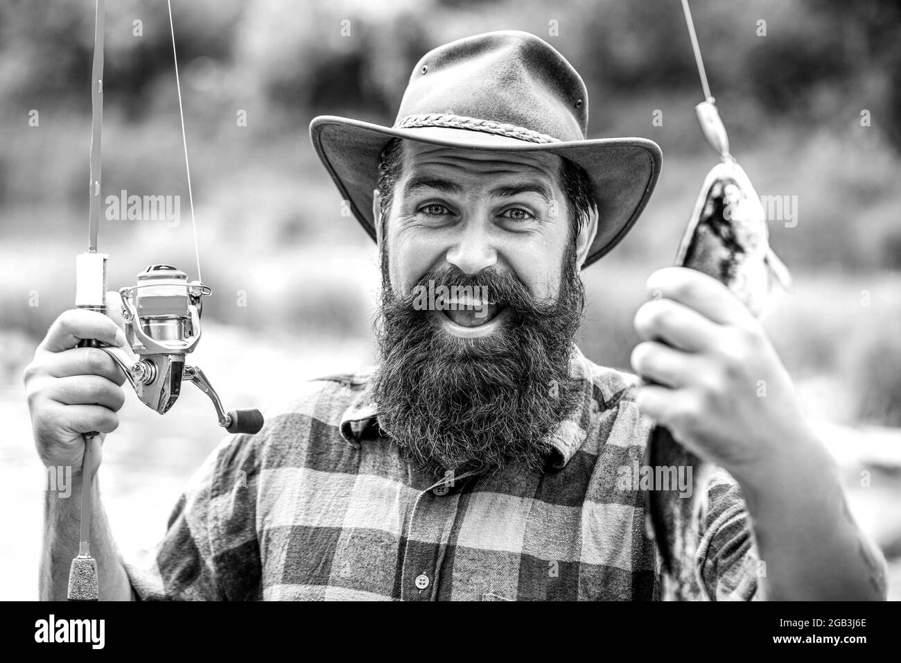 Man holding a trout fish. Fishing. Angler with fishing trophy. Fisherman and trout. Fishing backgrounds. Black and white Stock Photo