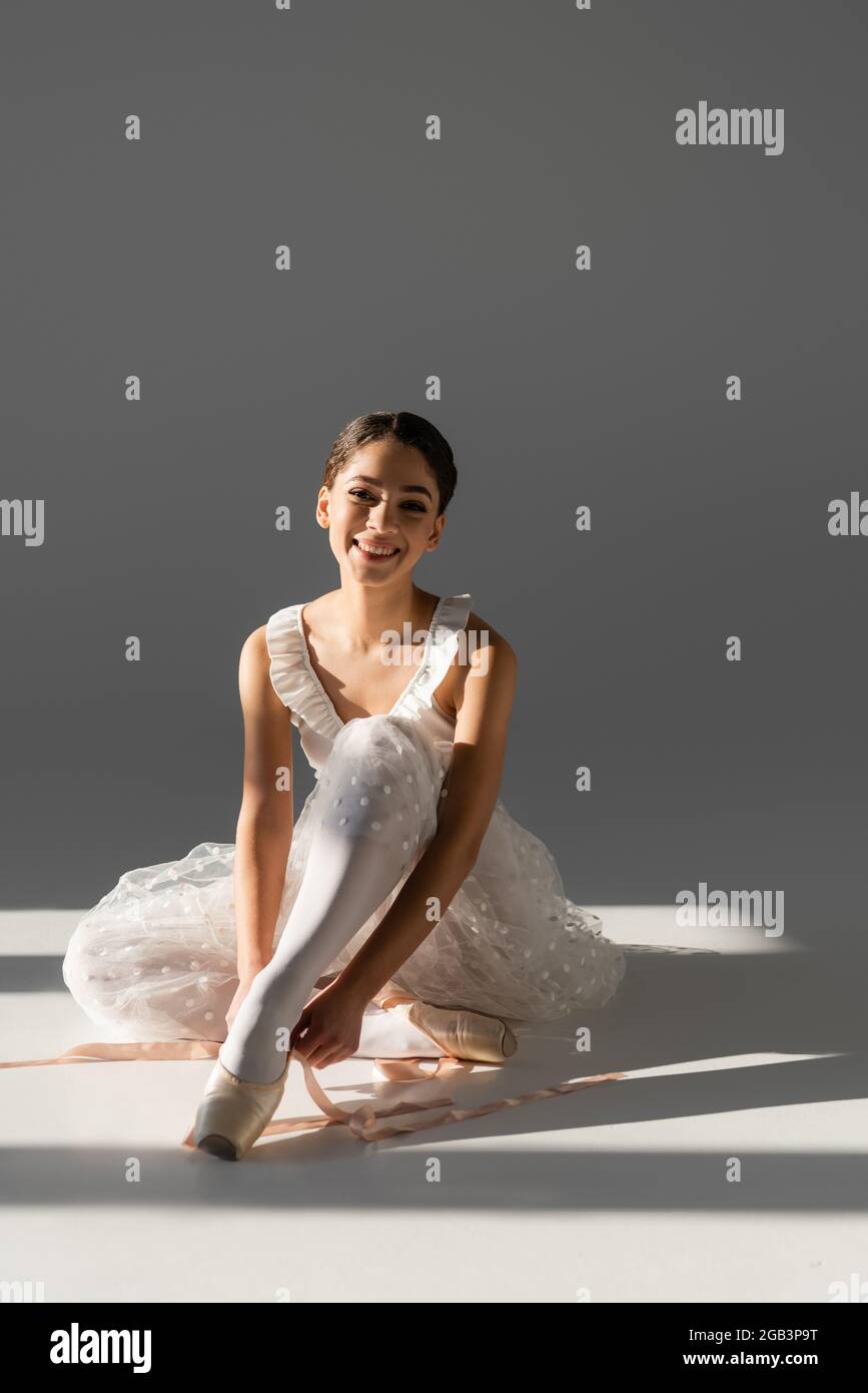 Young ballerina wearing pointe shoes on grey background Stock Photo Alamy