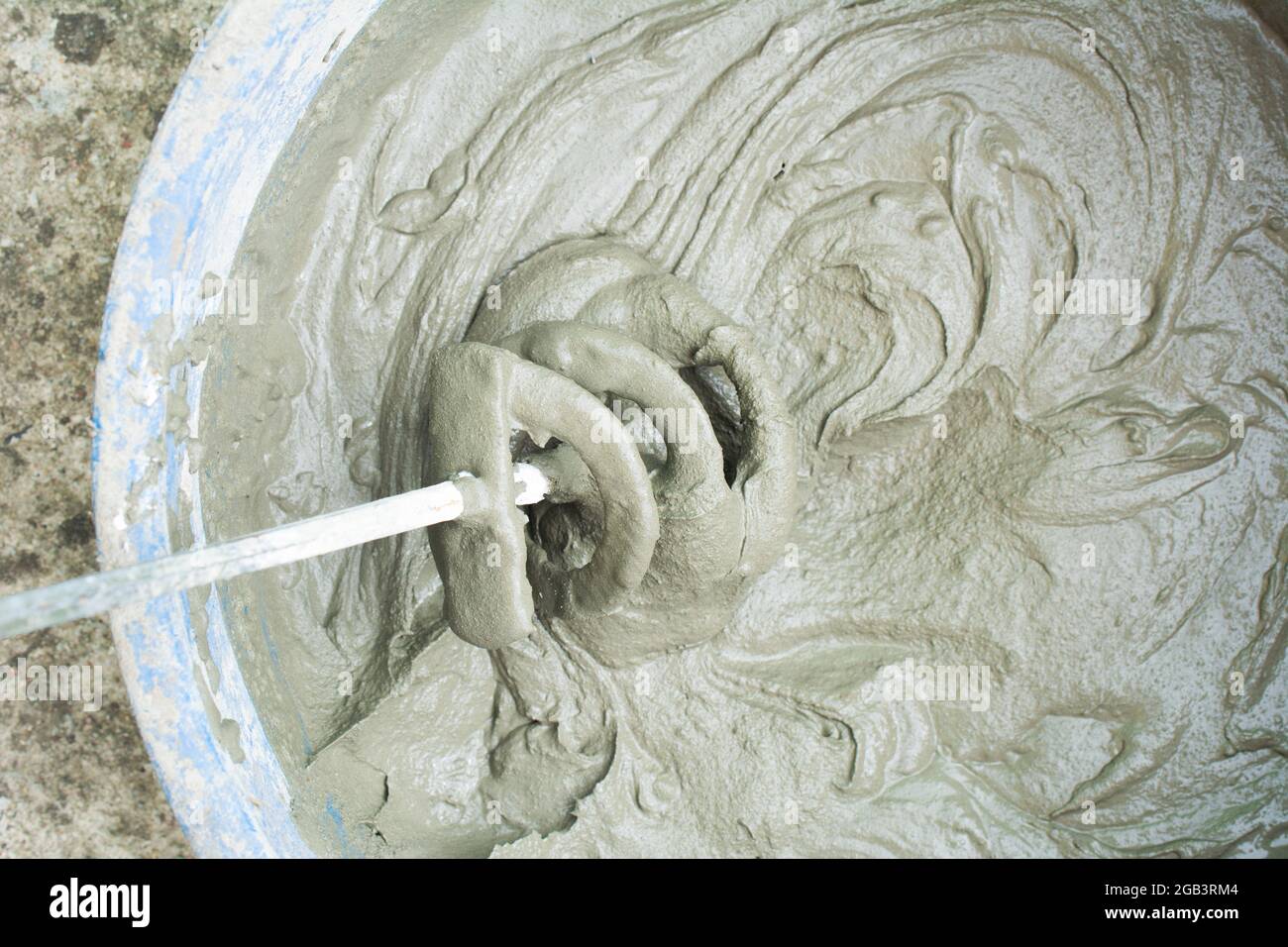 Construction technicians mixing concrete with electrical drill and