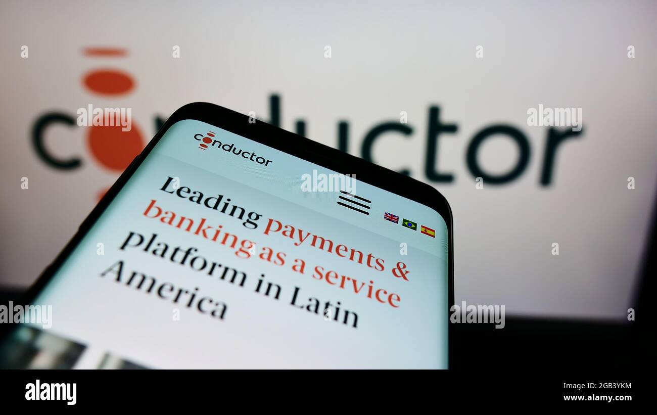 Mobile phone with website of Brazilian payment company Conductor Technology Ltd. on screen in front of logo. Focus on top-left of phone display. Stock Photo