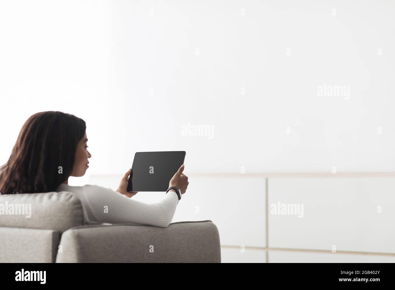 African american woman controlling smart home devices using digital ...