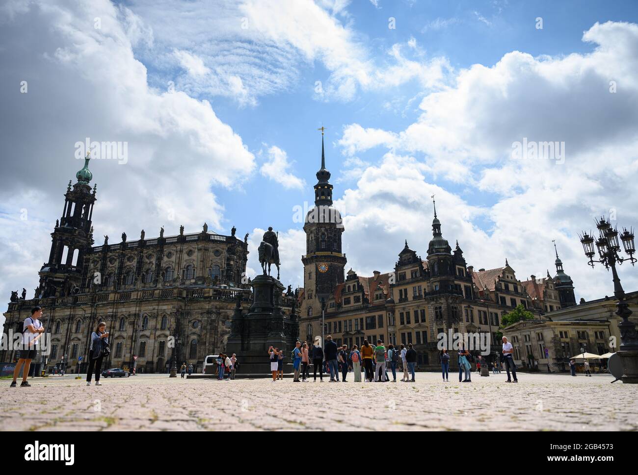 02 August 2021, Saxony, Dresden: Tourists stand on the Theaterplatz in front of the Hofkirche (l-r), the equestrian statue of King Johann, the Hausmannsturm, the Residenzschloss and the Schinkelwache. Photo: Robert Michael/dpa-Zentralbild/dpa Stock Photo