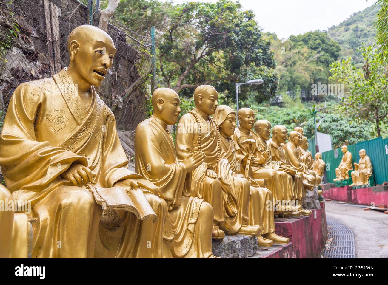 HONG KONG - 10TH APRIL, 2017: Closeup to rows of Buddhas on the path leading up to Ten Thousand Buddhas Monastery, located in Sha Tin, Hong Kong Stock Photo