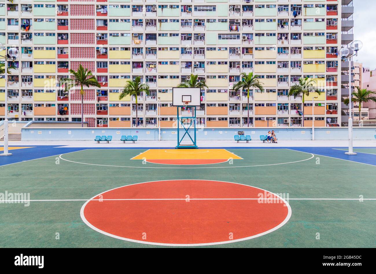 HONG KONG - 10TH APRIL 2017: A basketball court and colourful facades and architecture in Kowloon, Hong Kong. People can be seen. Stock Photo