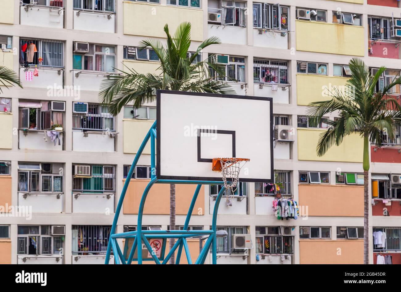 Closeup to a basketball hoop with colourful facades in the background in Hong Kong. Stock Photo