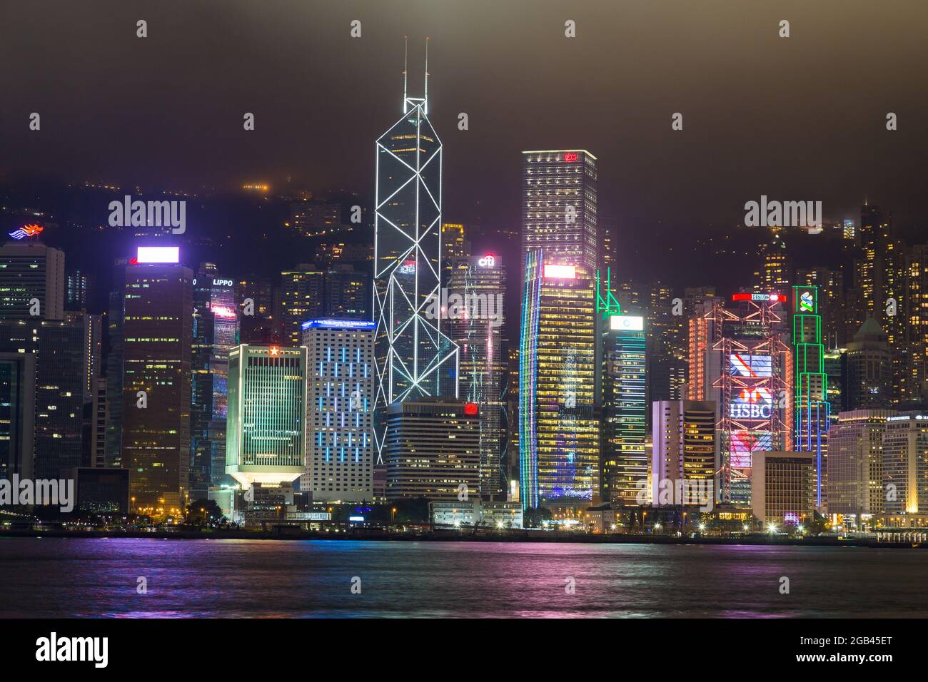 HONG KONG - 10TH APRIL 2017: Hong Kong Island skyline at night with views across Victoria Habour. Skyscrapers and office buildings can be seen. Stock Photo