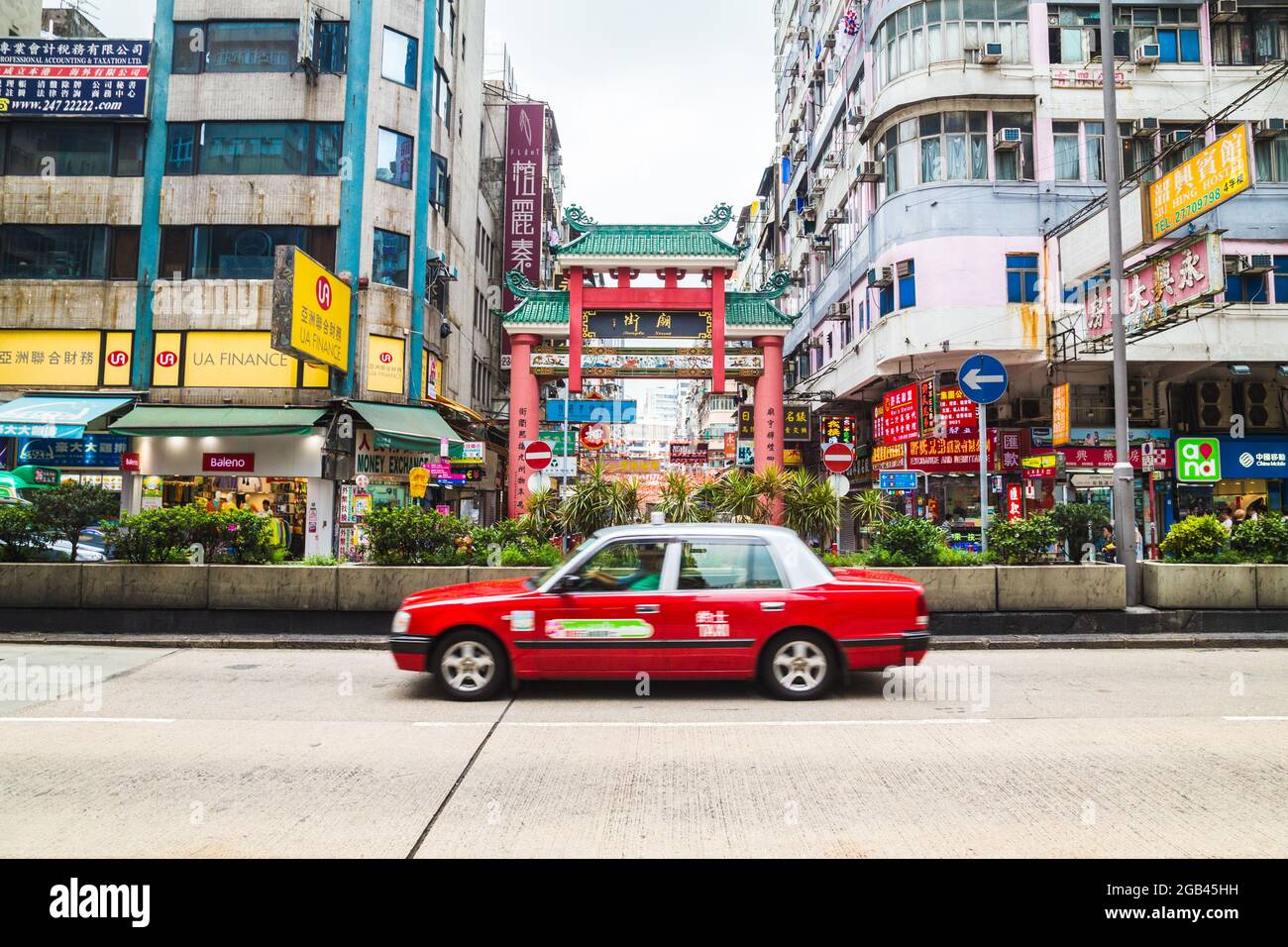 HONG KONG - 11TH APRIL 2017: Streets in Hong Kong showing buildings, shops and a taxi. People can also be seen. Stock Photo