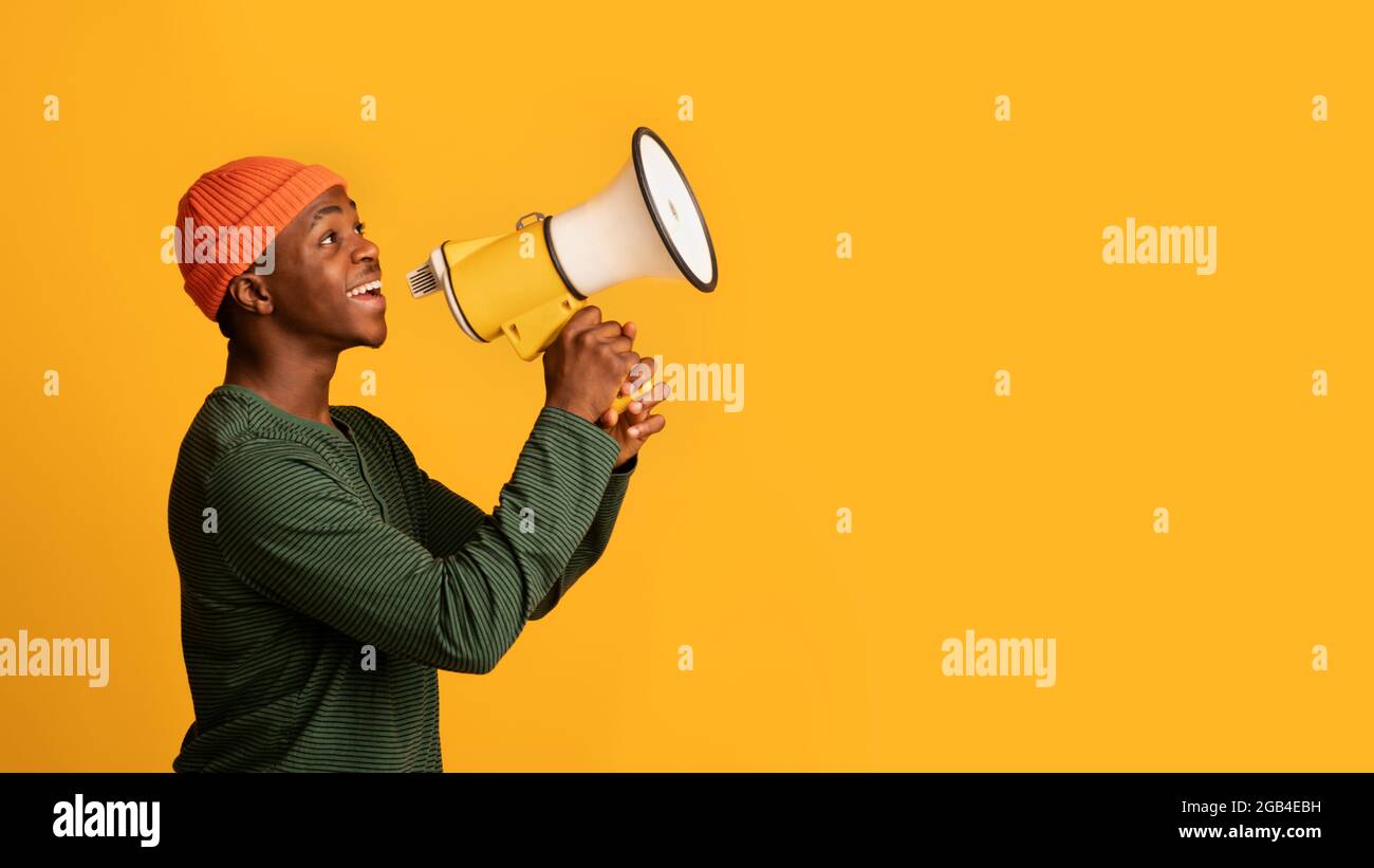 Portrait Of Black Hipster Guy With Megaphone In Hands Making Announcement Stock Photo