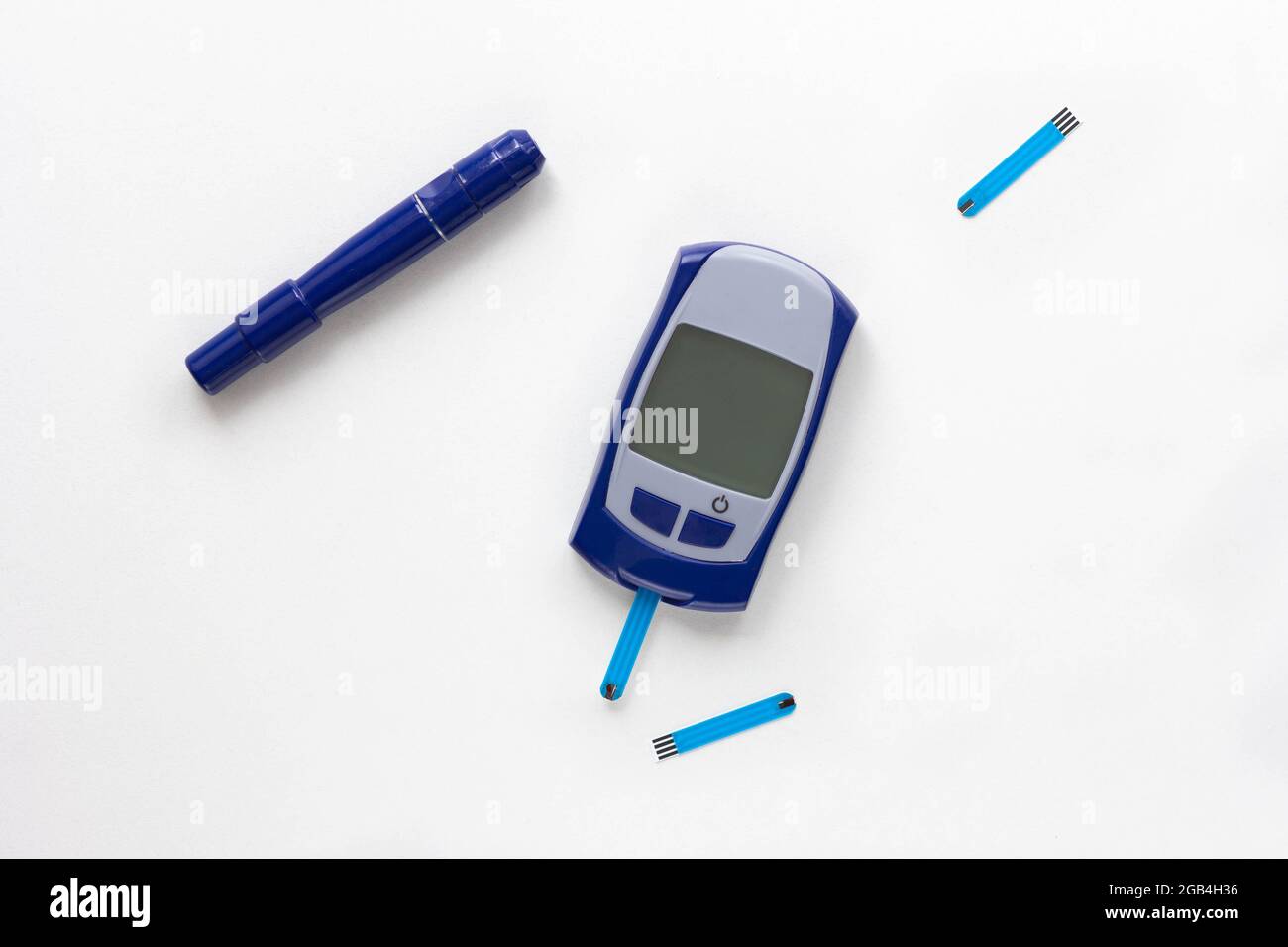 Top view of blood glucose meter, lancet and test strip in it on white