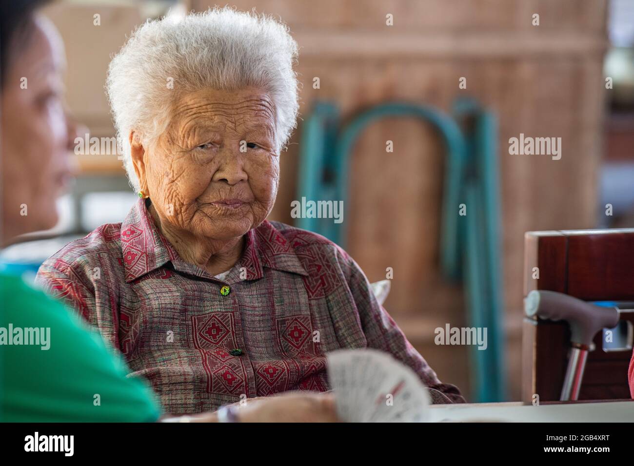 Portrait of an older lady in China playing cards with her friends Stock Photo