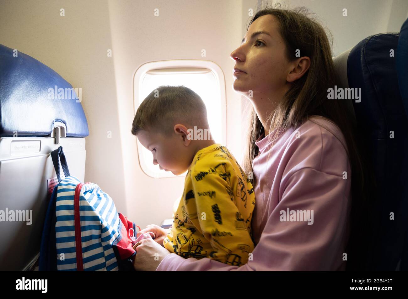 mother-with-her-baby-on-her-knees-on-the-plane-stock-photo-alamy