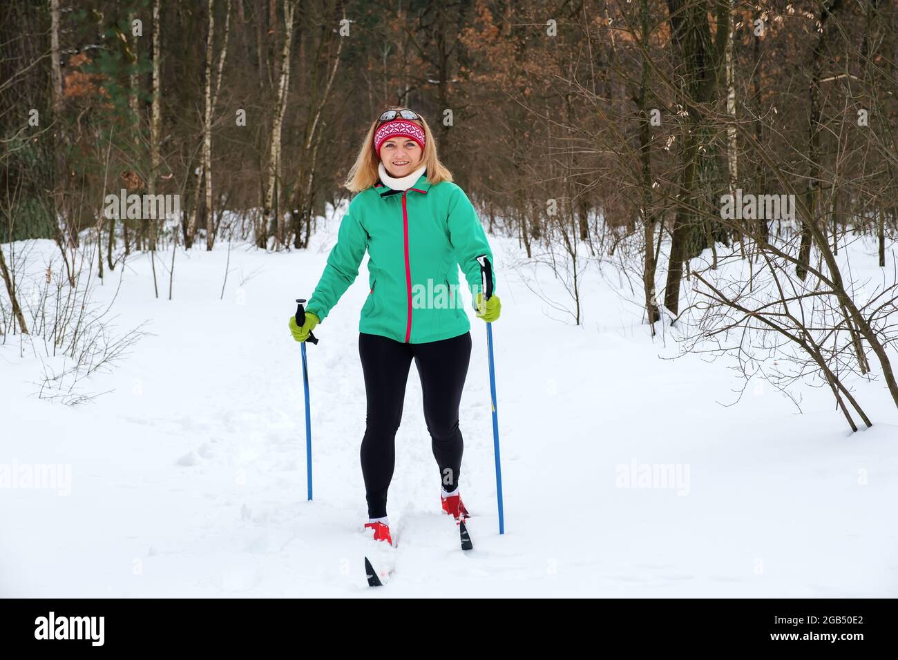 Woman goes cross-country skiing in the winter in the forest Stock Photo