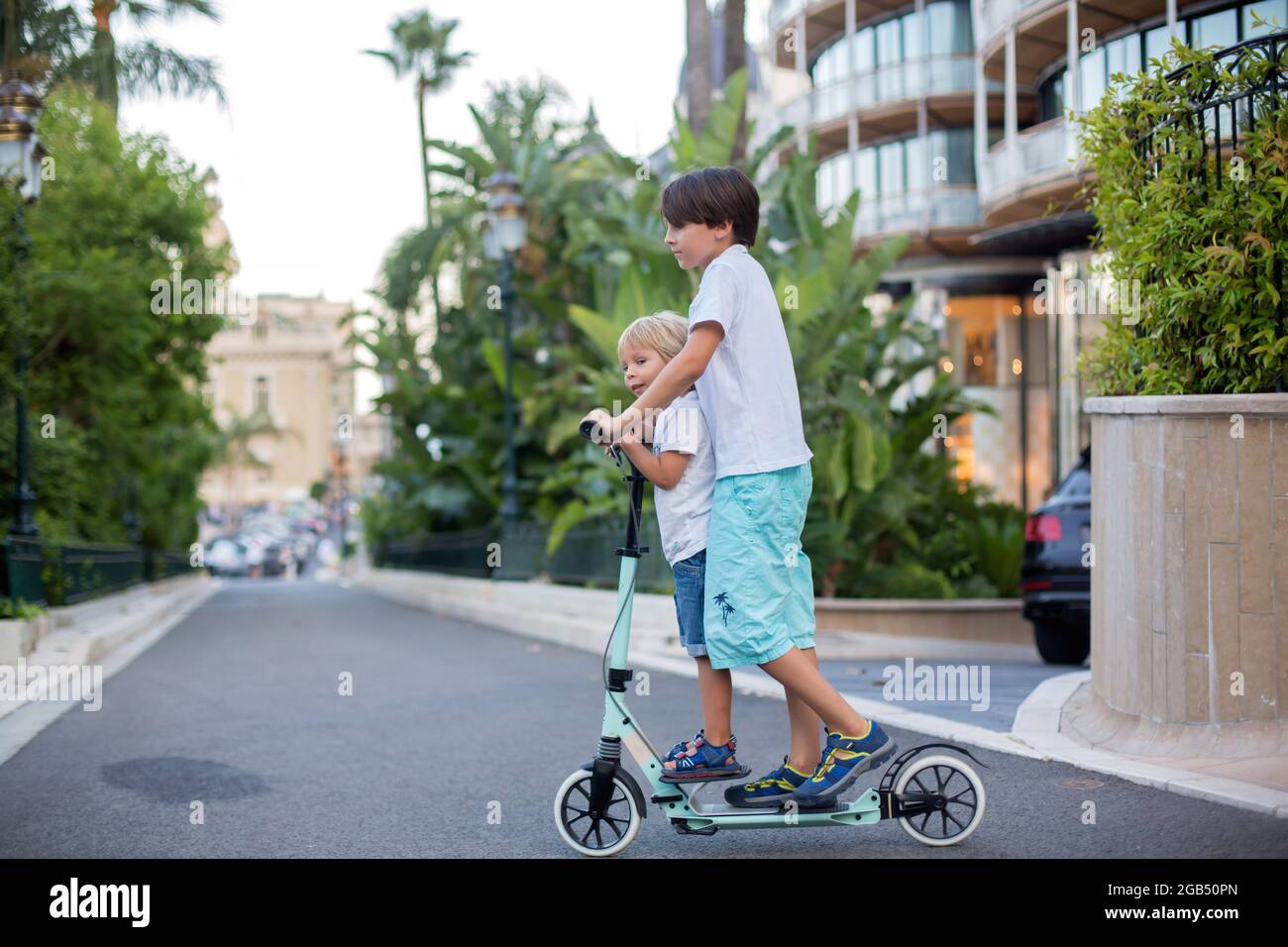 Cute preteen boy, riding scooter in Monaco village on sunset, kid on  pedestrian cross Stock Photo - Alamy