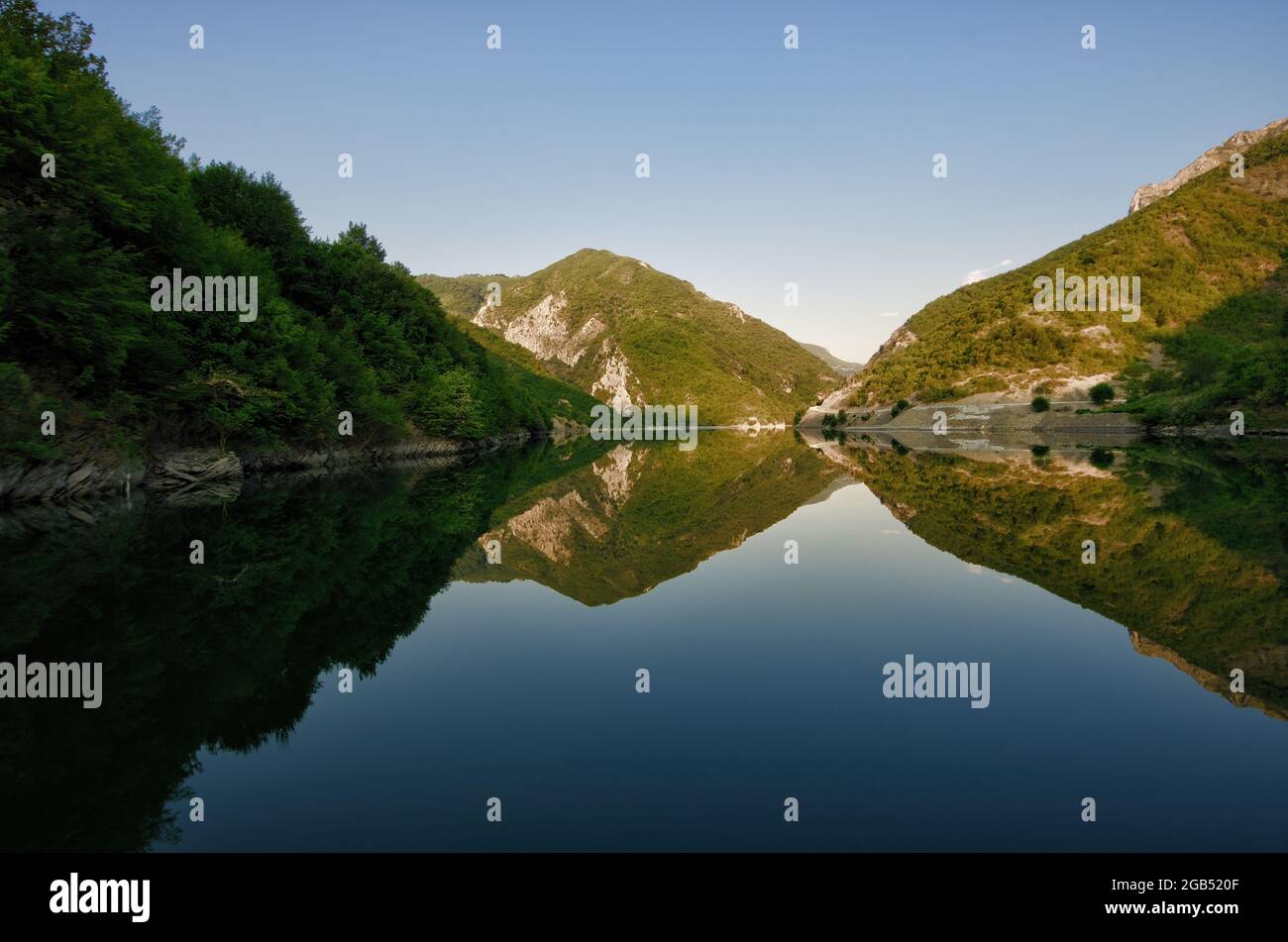 mountain landscape in Albania its clear reflection on the waters of Lake Koman in the morning Stock Photo