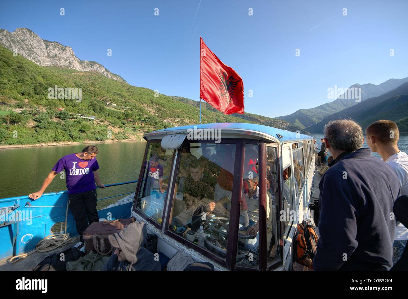 flag of Albania on ferry boat on Koman Lake crowded of people Stock Photo