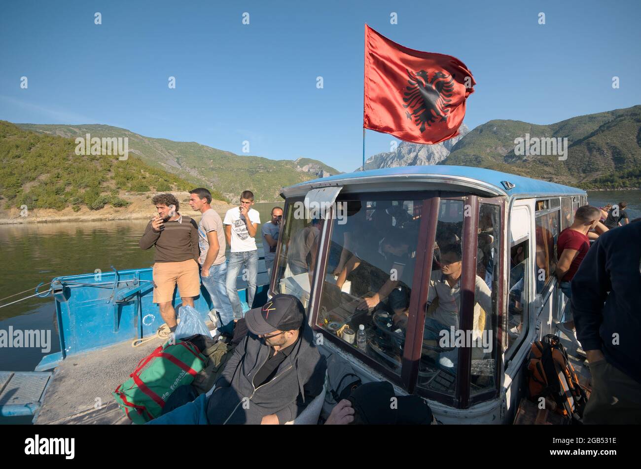 flag of Albania on ferry boat on Koman Lake crowded of people Stock Photo