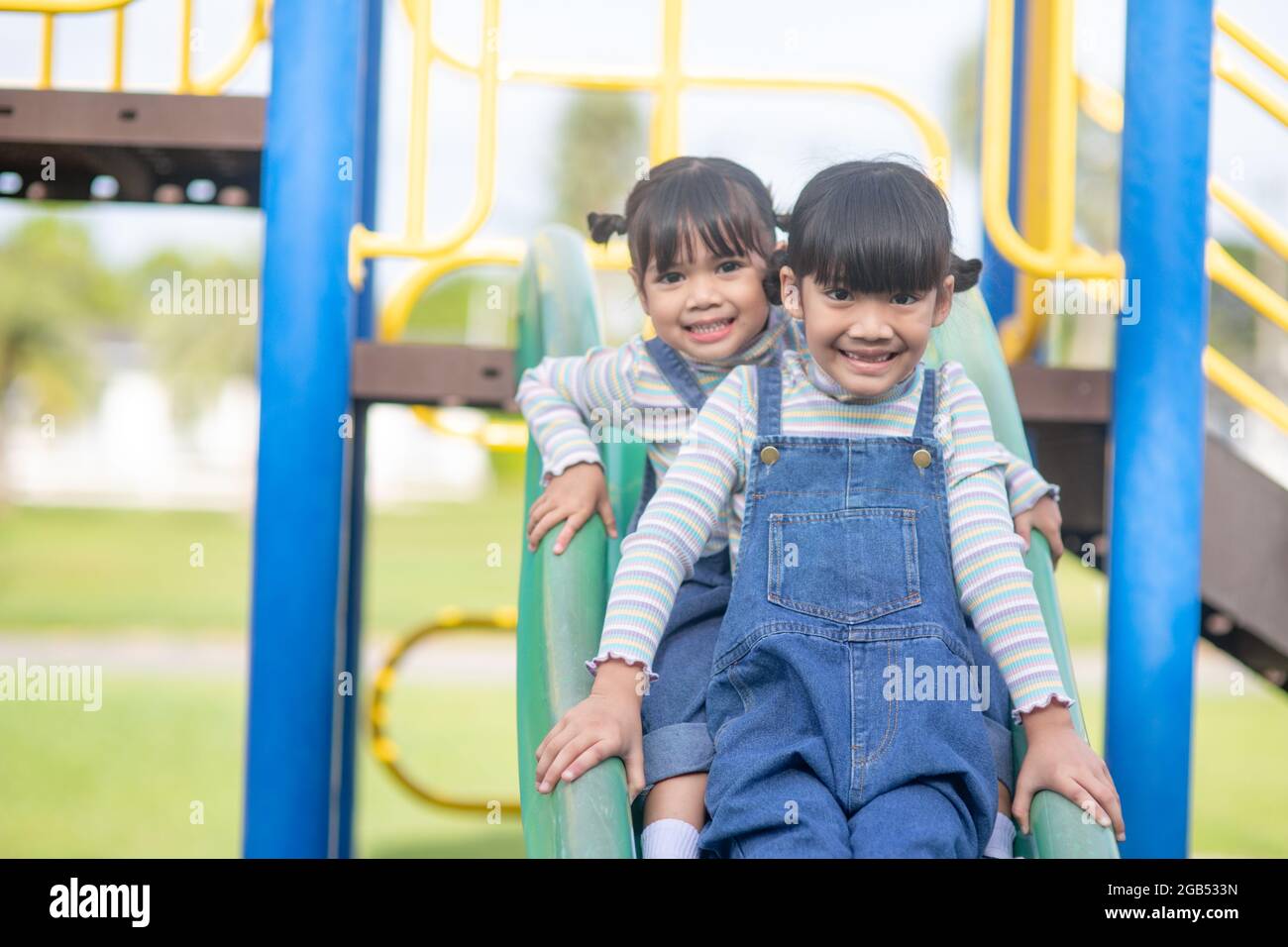 Two happy little asian kids playing outdoor in the sunny park Stock Photo -  Alamy