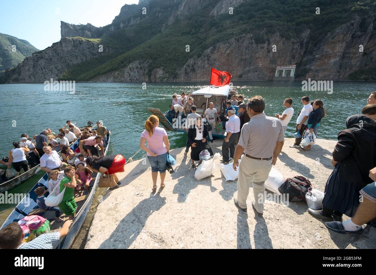 local people and tourists in northen of Albania lake Koman docking of the ferry boat for pick-up of passengers from Fierze to Koman and back - August Stock Photo