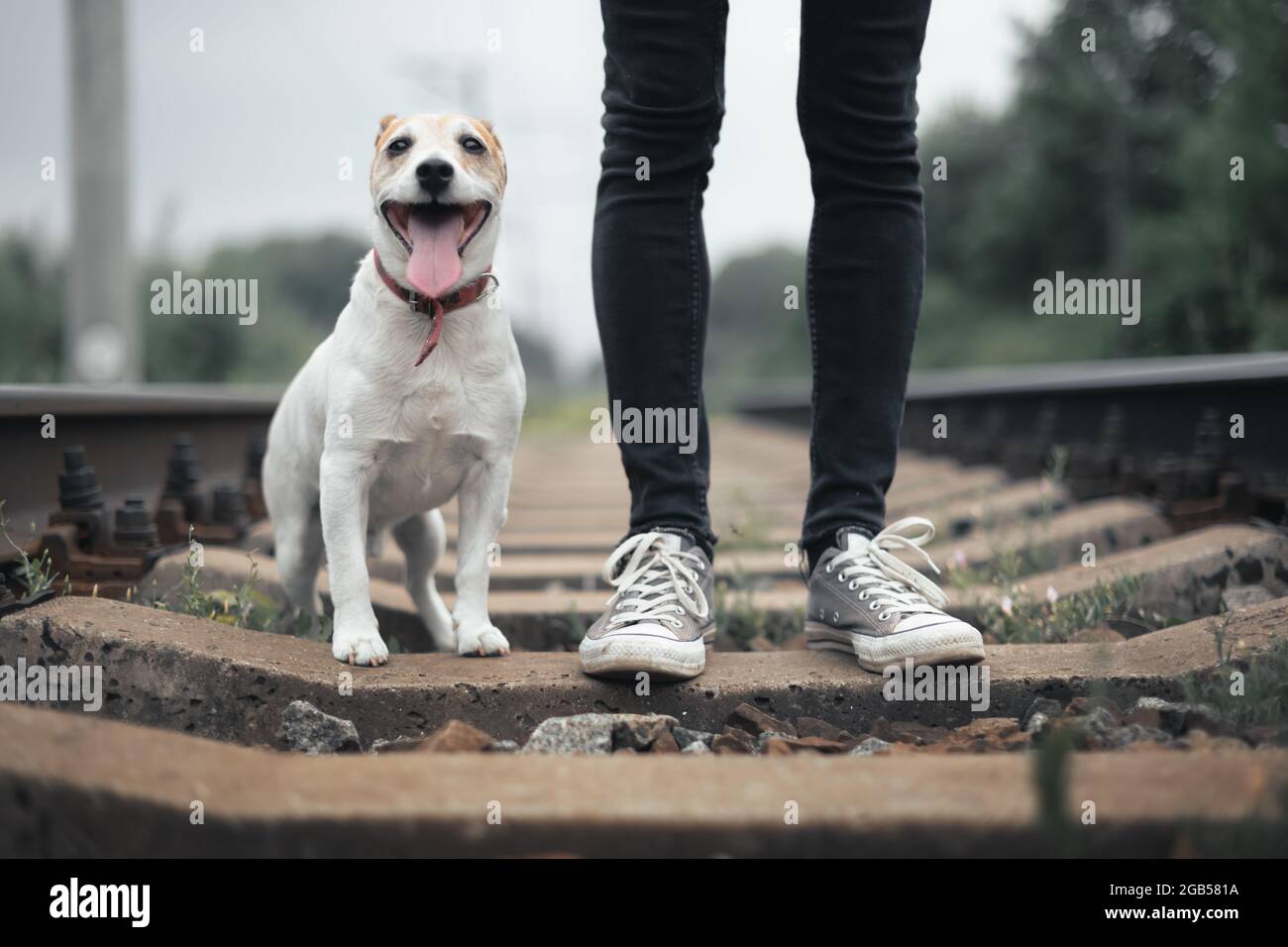 Hipster man in black jeans pants and grey sneakers on railway Stock Photo