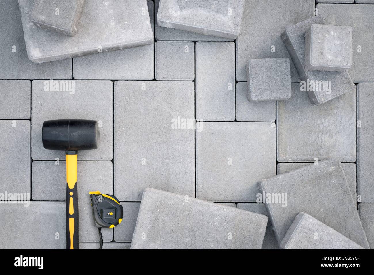 Paving stones paving background. Installing tools on foreground Stock Photo