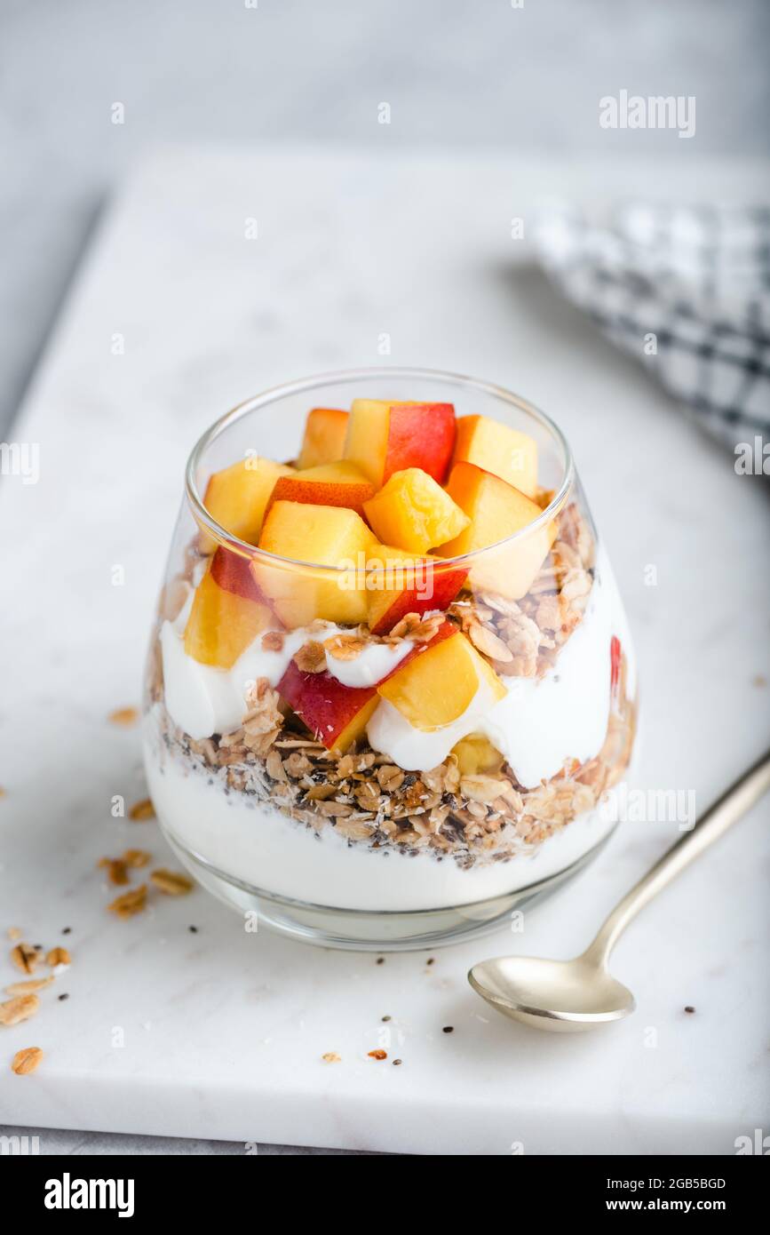 Yogurt granola parfait with peach in a glass. Healthy dessert food low