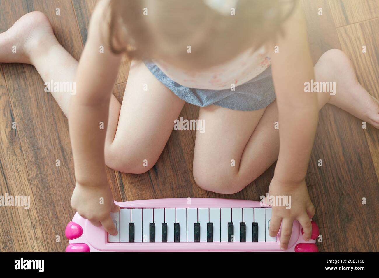 Small kid learn play on toy piano above top floor view Stock Photo
