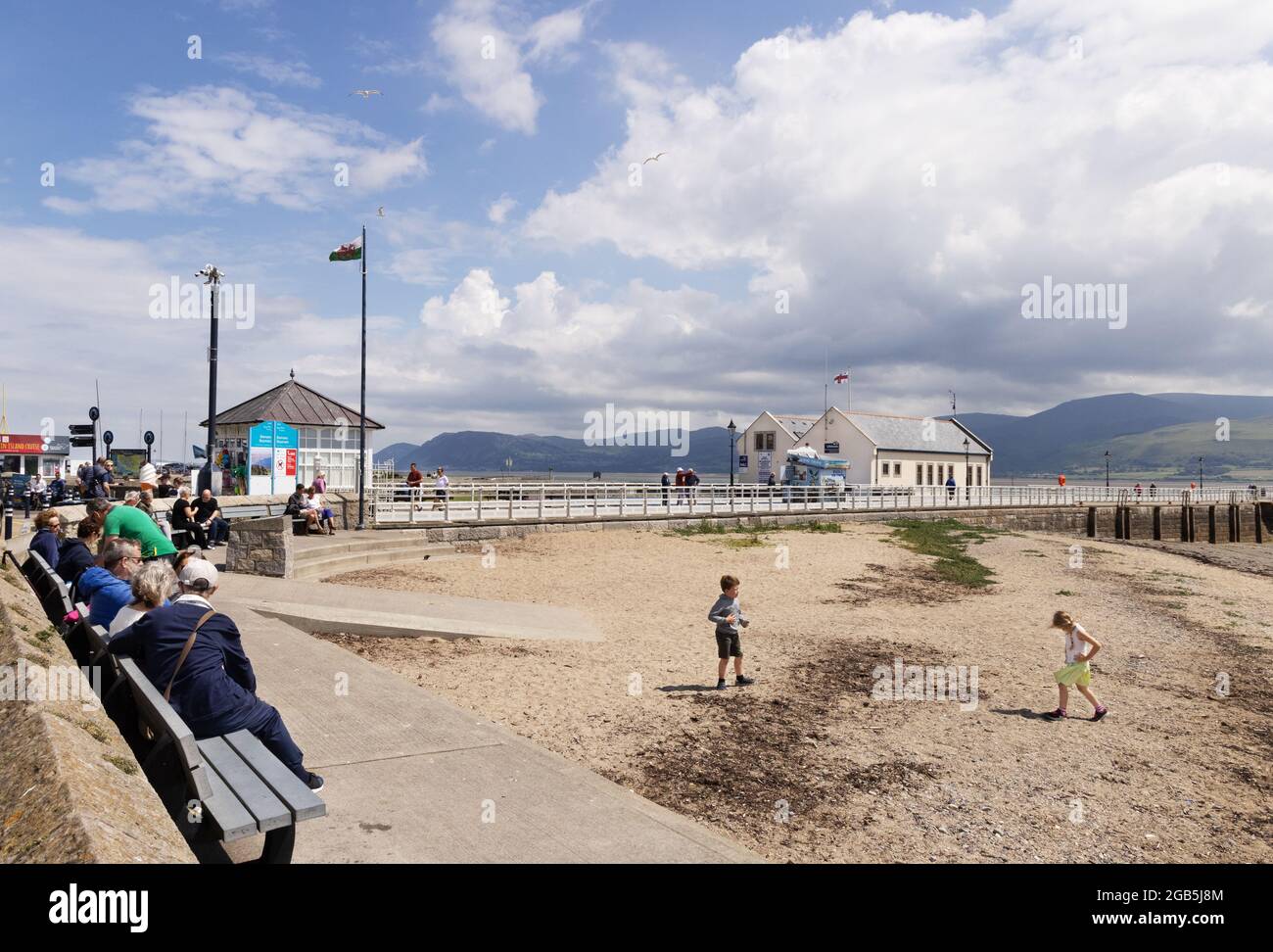 Staycation UK in summer; People on the beach, Beaumaris beach, Beaumaris seafront, Anglesey Wales Britain UK Stock Photo