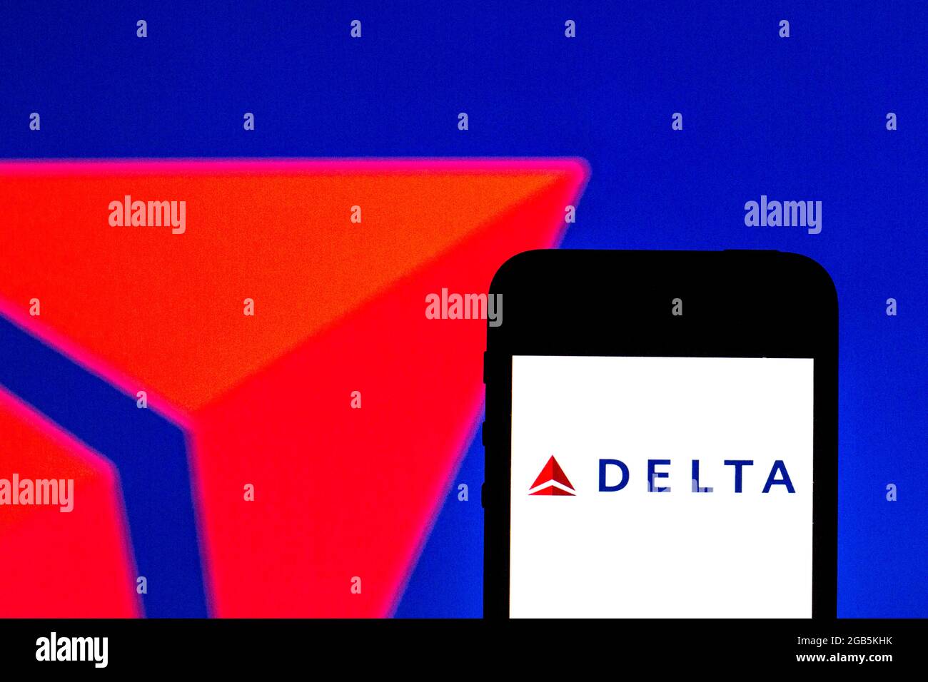 In this photo illustration a Delta Air Lines logo seen displayed on a smartphone and in the background. Stock Photo