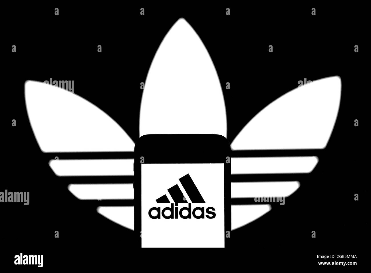 Barcelona, Spain. 31st July, 2021. In this photo illustration an Adidas  logo seen displayed on a smartphone and in the background. (Photo by Thiago  Prudencio/SOPA Images/Sipa USA) Credit: Sipa USA/Alamy Live News