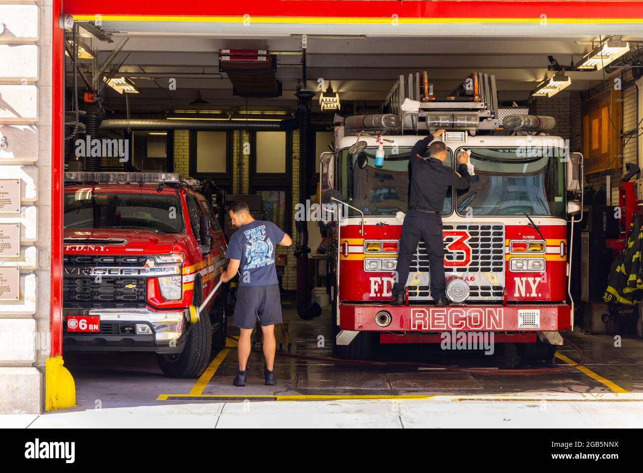 Firefighters wash the Fire trucks at garage of FDNY Ladder 3 NYC. Stock Photo