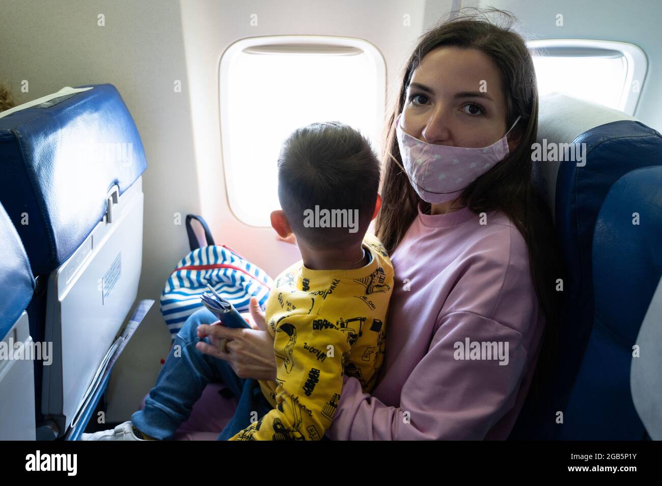 mother-with-her-baby-on-her-knees-on-the-plane-stock-photo-alamy
