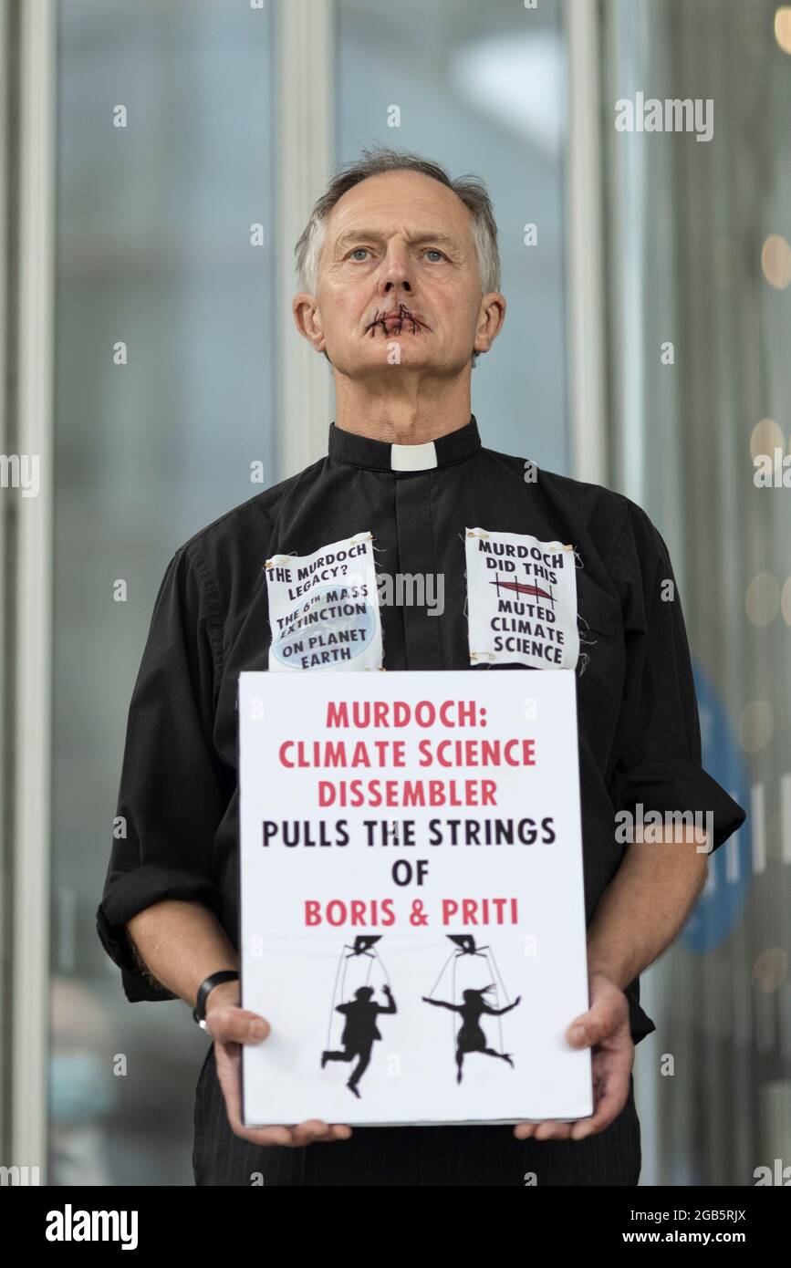 London, UK. August 2nd 2021: Reverend Tim Hewes, aged 71, sewed his lips shut outside News UK offices at lunchtime today. His action was to draw attention to the silencing of climate science by Rupert Murdoch and News Corp, which has led to a catastrophic lack of effective action to tackle the climate crisis. He held placards reading “Murdoch did this, muted climate science”, “Murdoch to the dock for ecocide”, “The Murdoch legacy? The 6th Mass Extinction on planet earth”. London, UK. Credit: Joshua Windsor/Alamy Live News Stock Photo