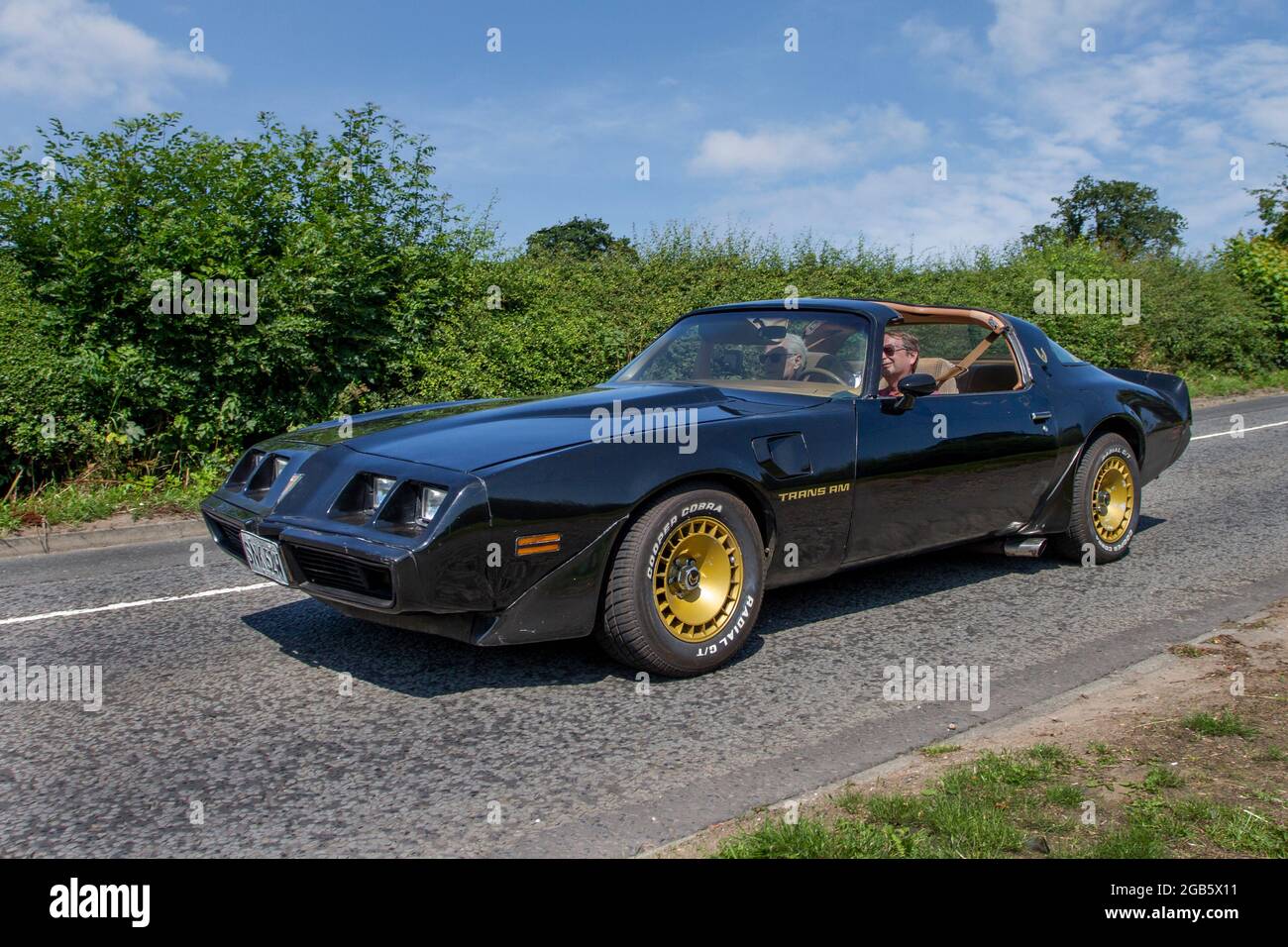 1980 80s black Pontiac Trans Am 4900cc American roadster, en-route to Capesthorne Hall classic July car show, Cheshire, UK Stock Photo