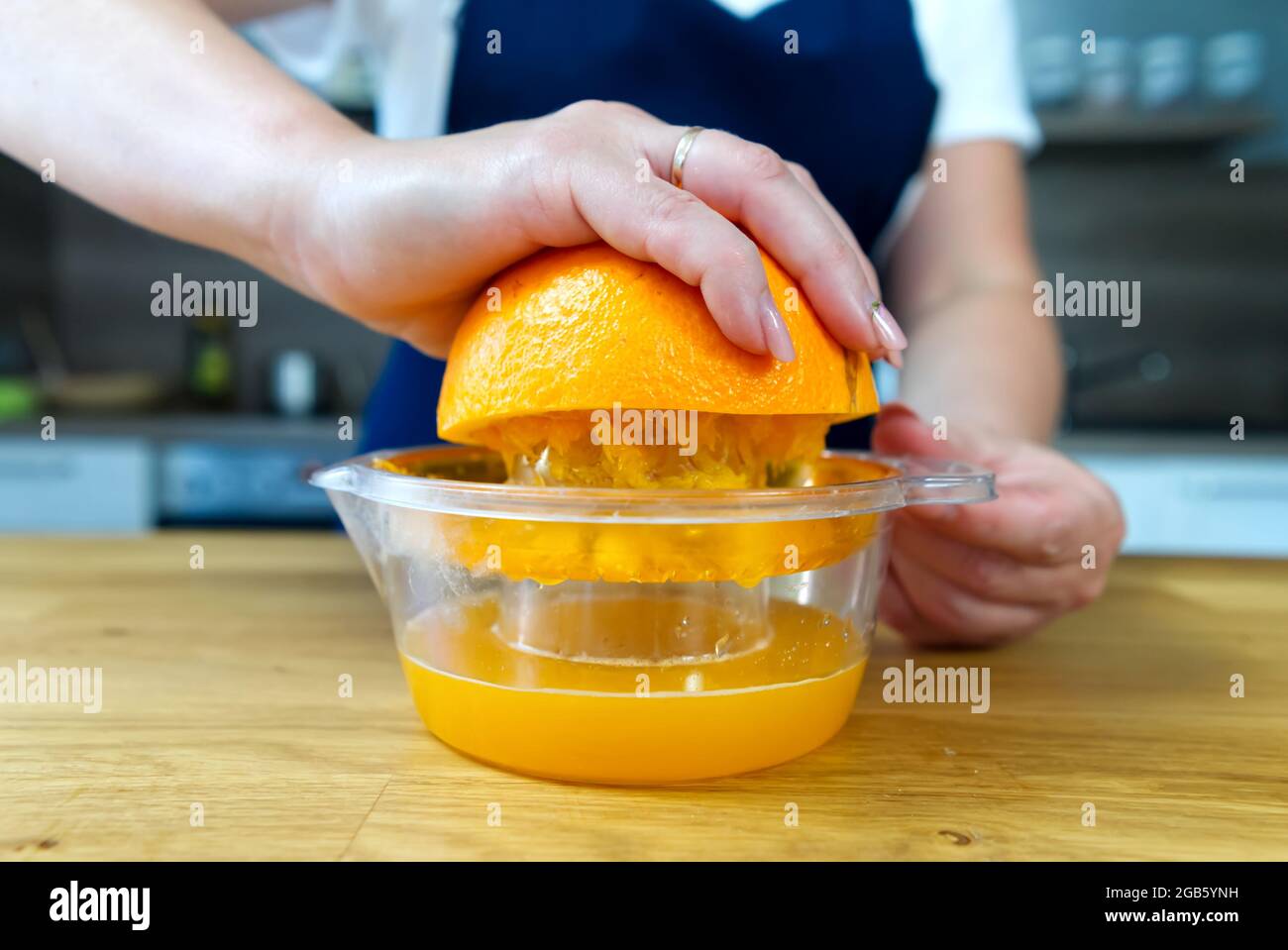 Hand squeezing orange juice. Close up fresh drink making process Stock Photo Alamy