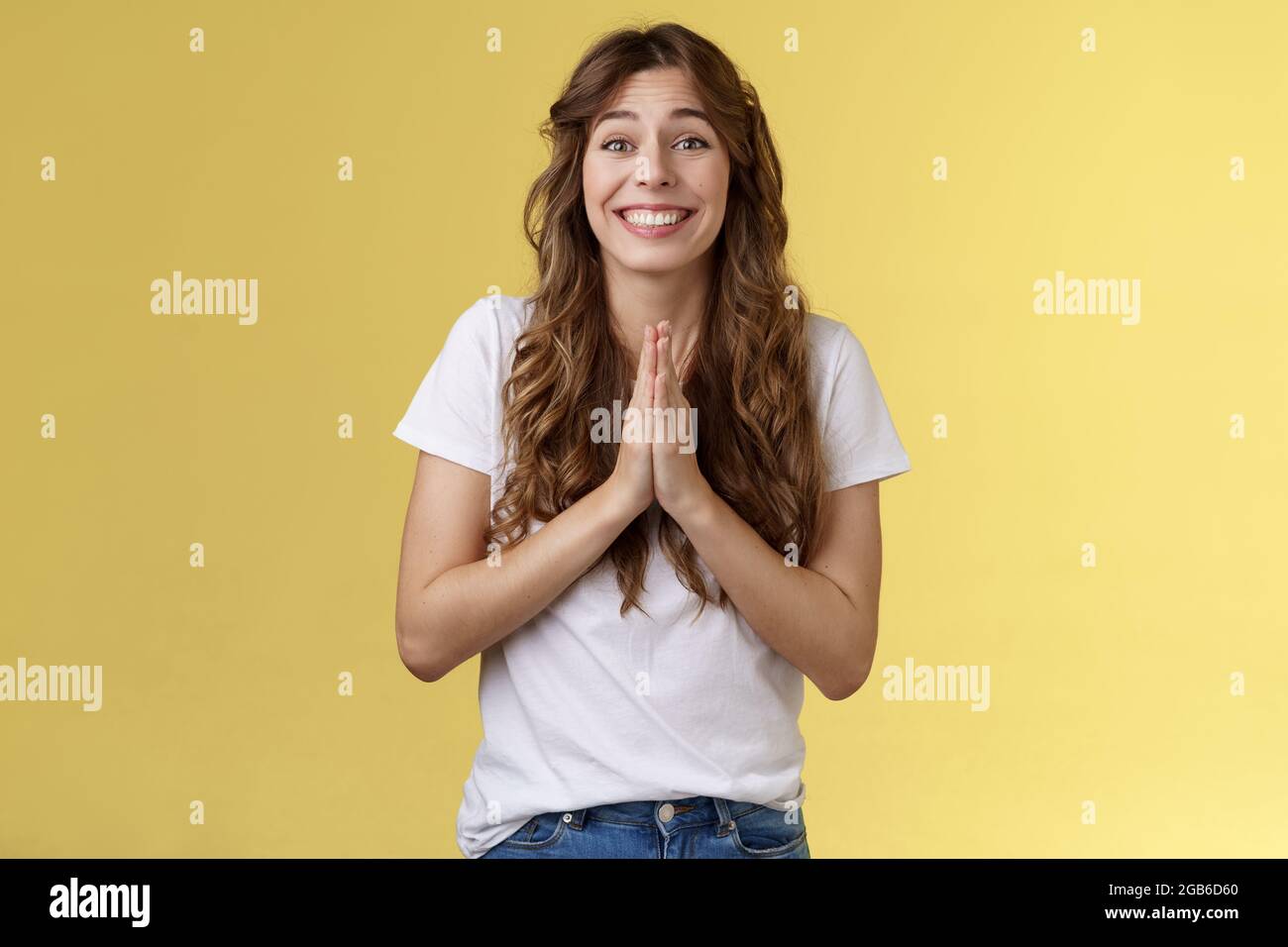 Please one small favor. Cute silly charming young girlfriend asking lend money press palms together praying supplication gesture implore you help Stock Photo