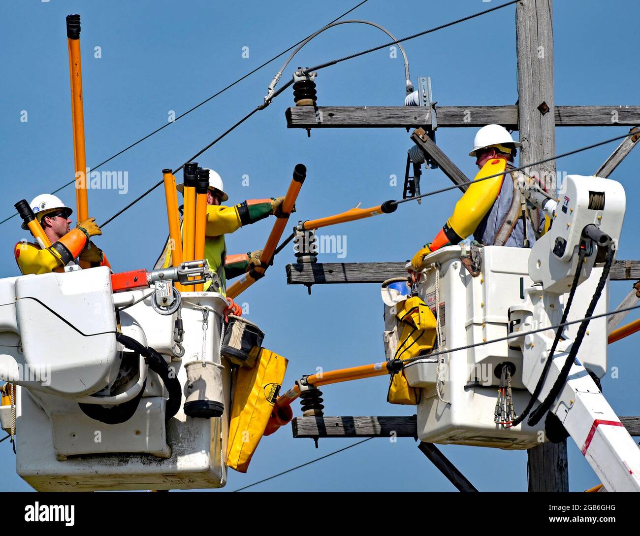 As part of improving the infrastructure of the local electrical grid a work  crew from Every electric power utility using full safety gear place covers  over the high tension wires to protect