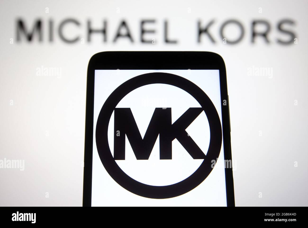 In this photo illustration, Michael Kors (MK) fashion brand logo seen on a  smartphone and a pc screen. (Credit Image: © Pavlo Gonchar/SOPA Images via  ZUMA Press Wire Stock Photo - Alamy