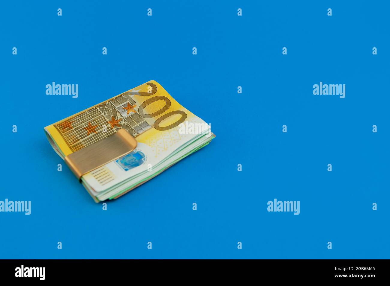 Money clip with euro bills on blue background Stock Photo - Alamy