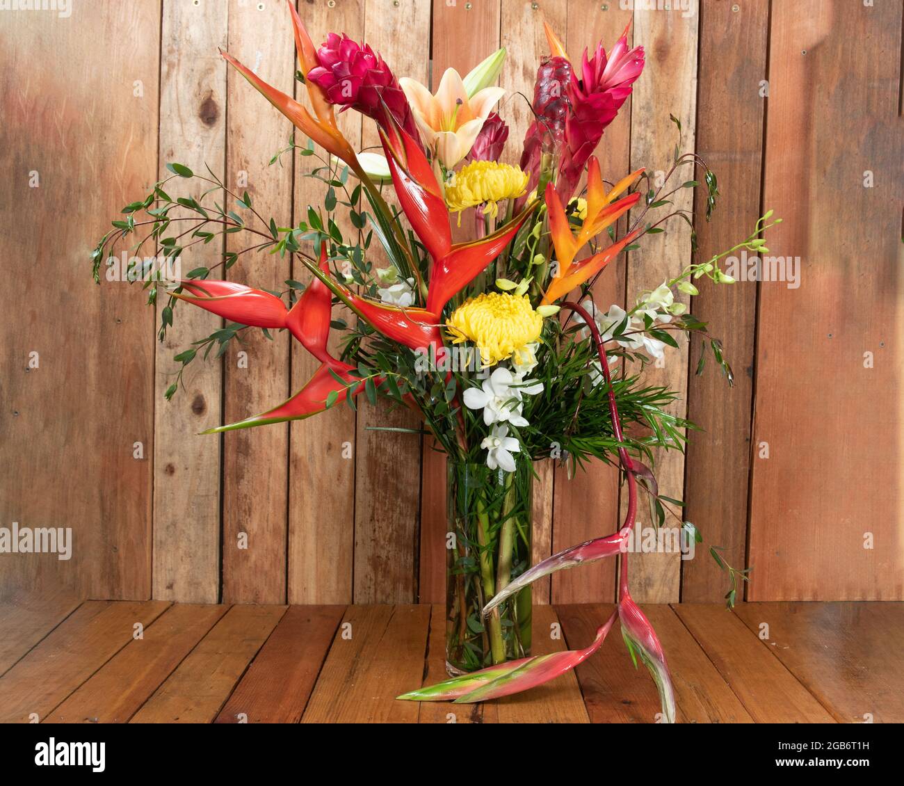 Beautiful bouquet of arranged yellow mums, orange stargazers, and birds of paradise given as an emotional sentiment. Stock Photo