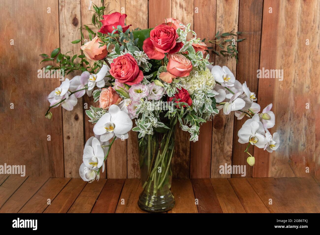 Beautiful bouquet of arranged roses, orchids, and filler leavesto create an expressive sentiment of flowers. Stock Photo