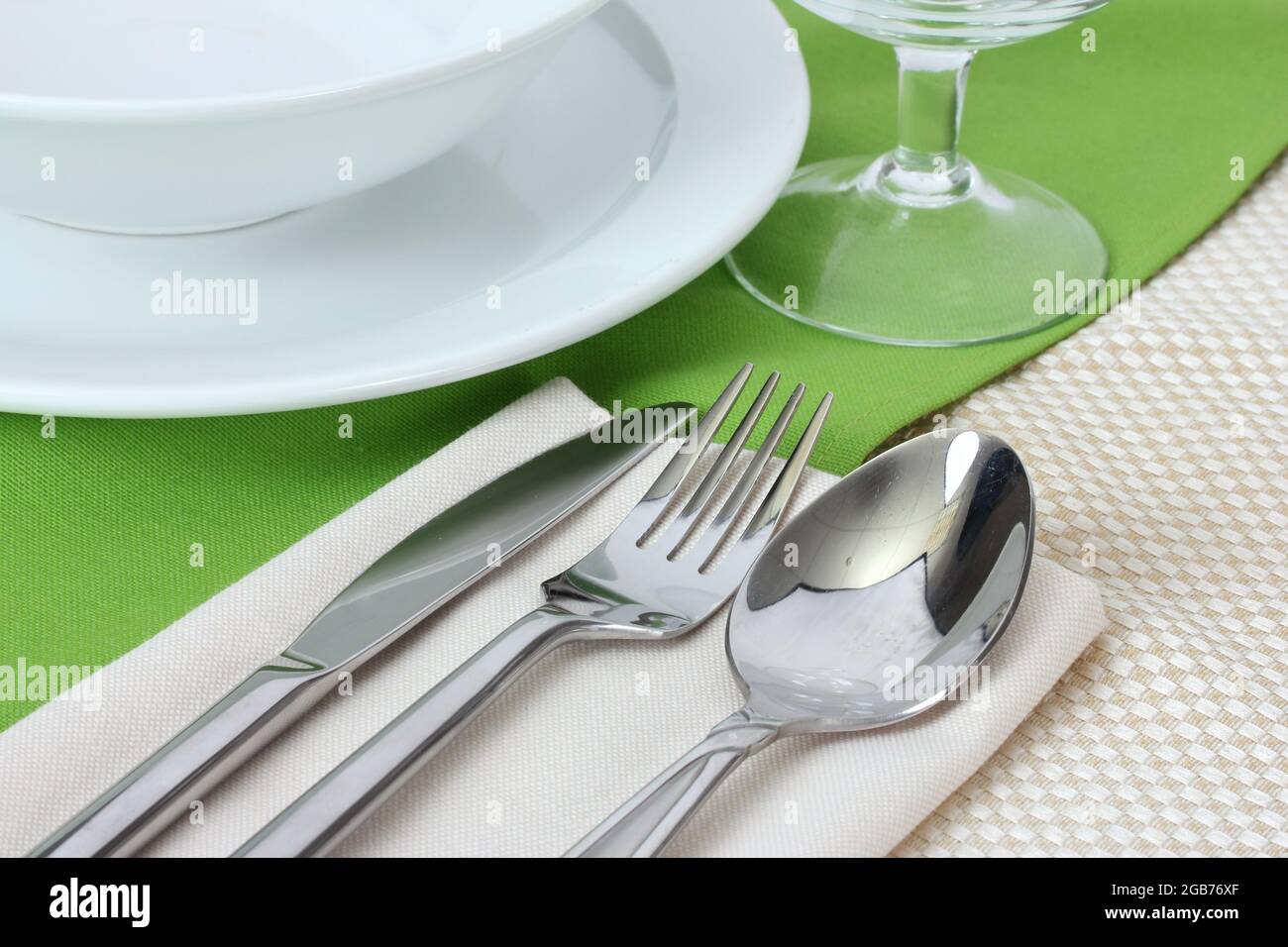 Table setting with fork, knife, spoon, plates, and napkin Stock Photo