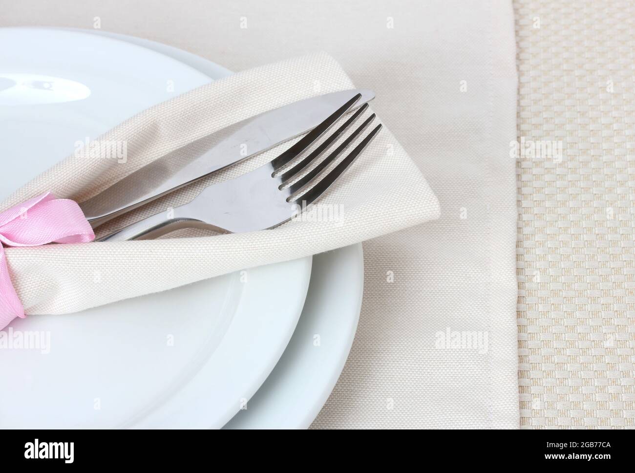 Table setting with fork, knife, plates, and napkin Stock Photo - Alamy