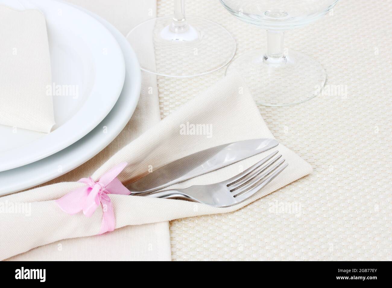Table setting with fork, knife, plates, and napkin Stock Photo Alamy